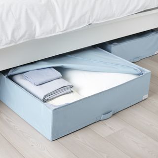 Blue under bed storage containers with white bedding