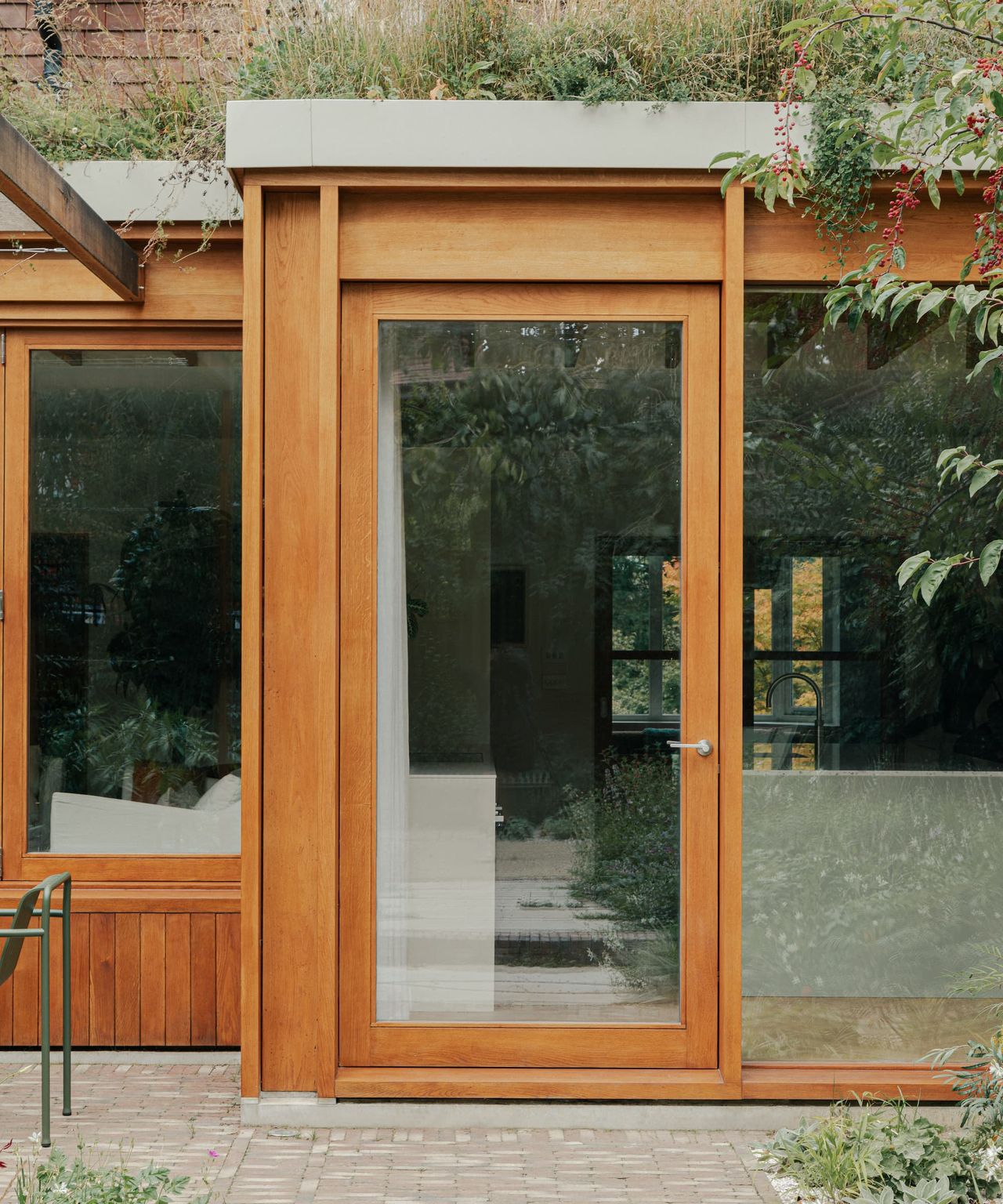 A timber back door with a green roof above it