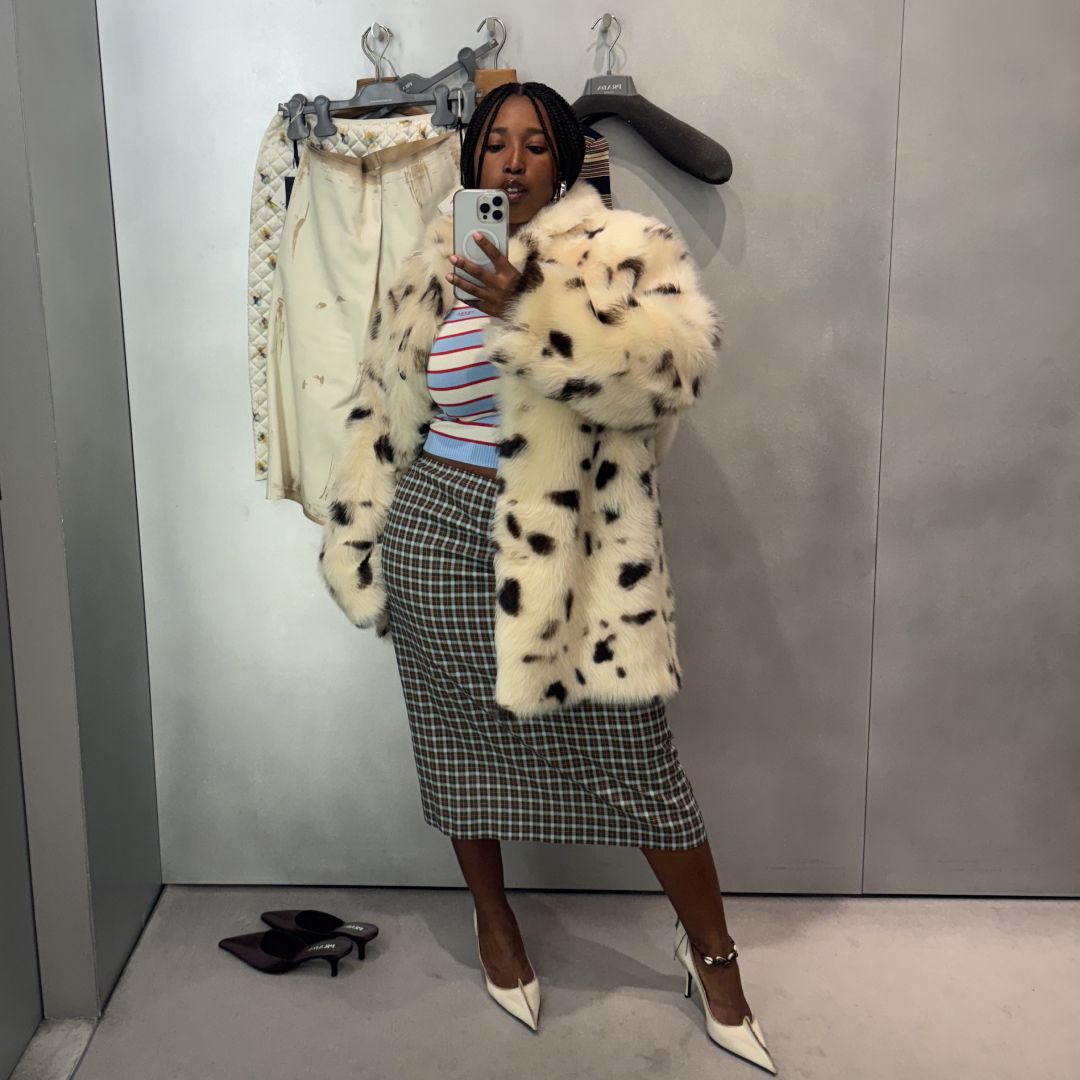 Mecca James-Williams in a white fur coat, blue and white striped polo shirt, and black checked skirt