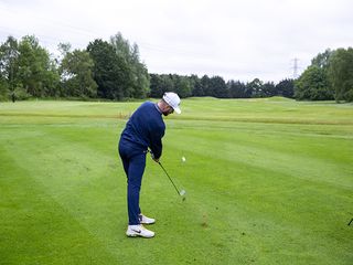 Barry Plummer hitting an iron shot at Burhill Golf Club