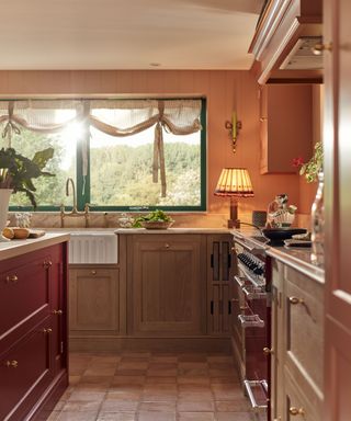 A pink and red kitchen with a fluted edge butler's sink