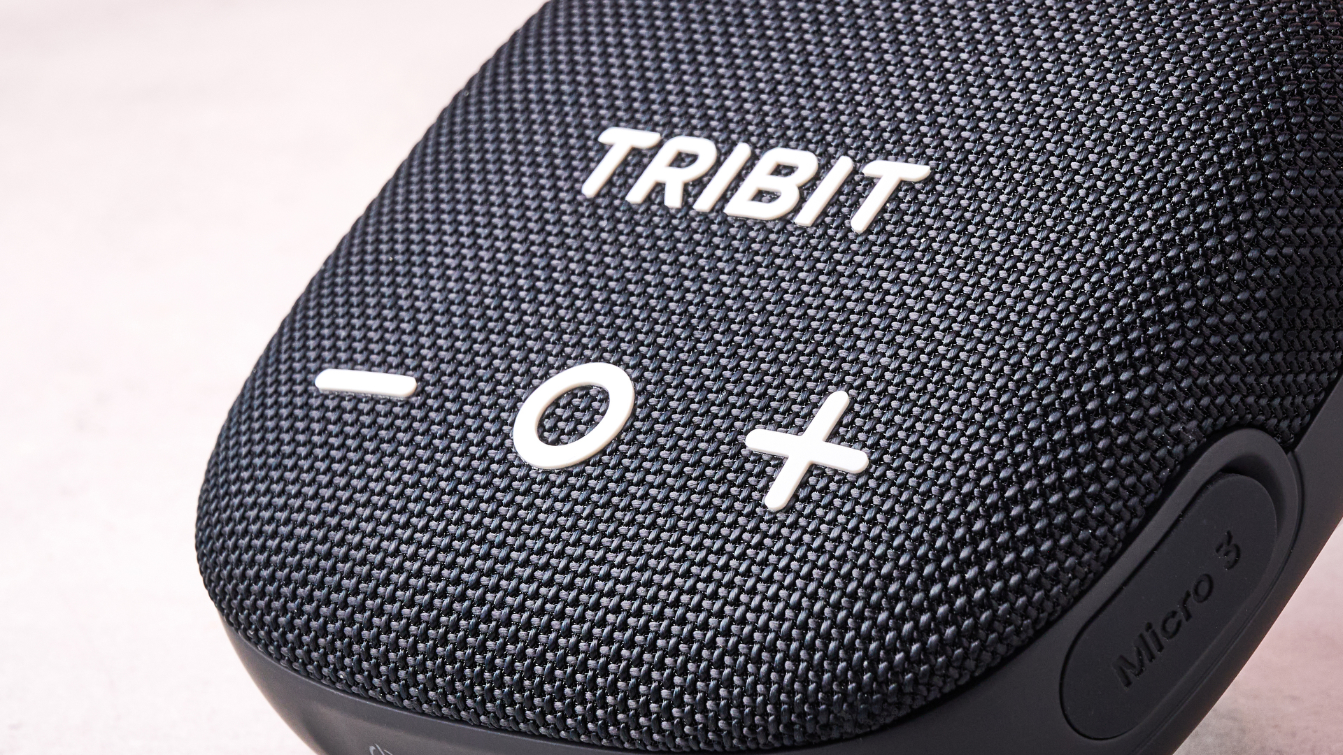 A closeup of the play and volume buttons on the front of the Tribit Stormbox Micro 3.