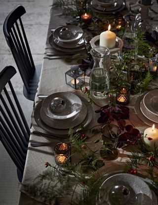 rustic Christmas table setting with grey tableware, foliage and candles