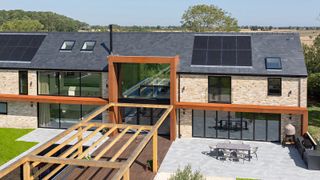 modern self-build house with contemporary glazing on the rear elevation and solar panels on the roof