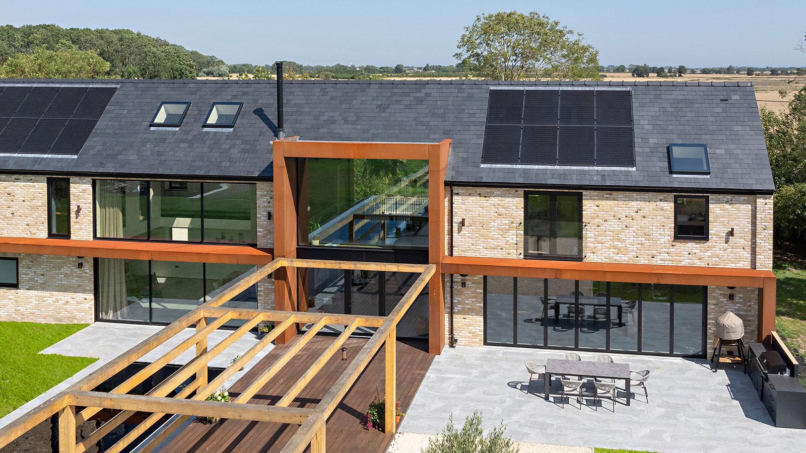 modern self-build house with contemporary glazing on the rear elevation and solar panels on the roof
