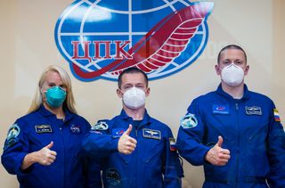 NASA astronaut Kate Rubins (left) and Russian cosmonauts Sergey Ryzhikov (center) and Sergey Kud-Sverchkov (right) of Roscosmos pose for a photo while in quarantine on Oct. 13, 2020 ahead of their Oct. 14, 2020 flight to the International Space Station.