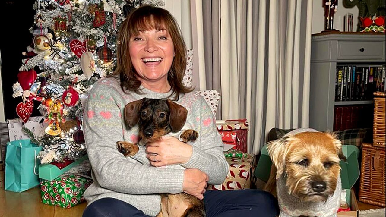 Lorraine Kelly with her dog and her daughter&#039;s dog beside a Christmas tree