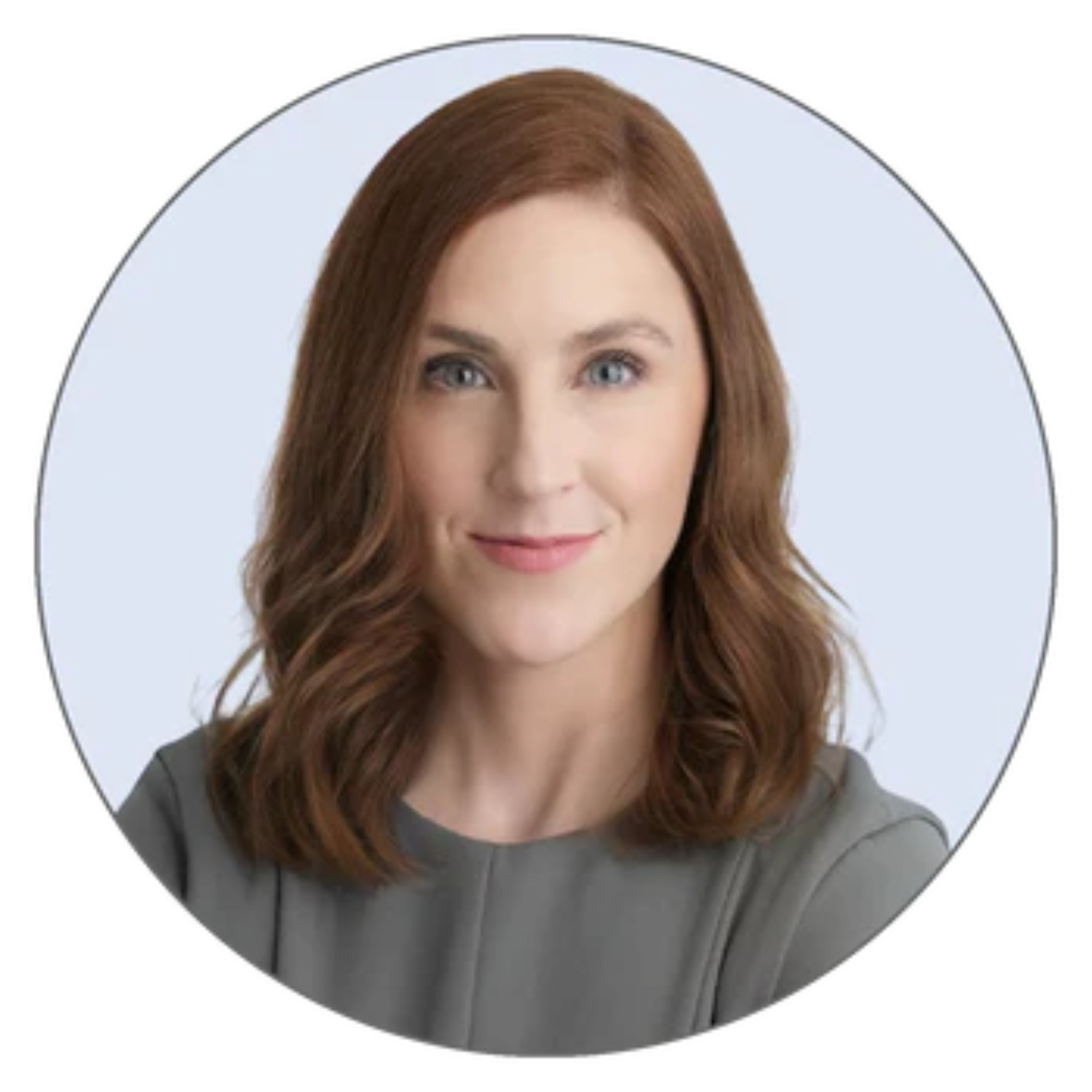 A headshot of a woman with shoulder-length auburn hair in a gray top