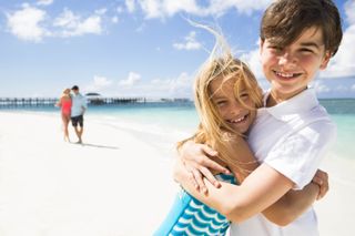 A family smiling on a beach on Nassau Paradise Island