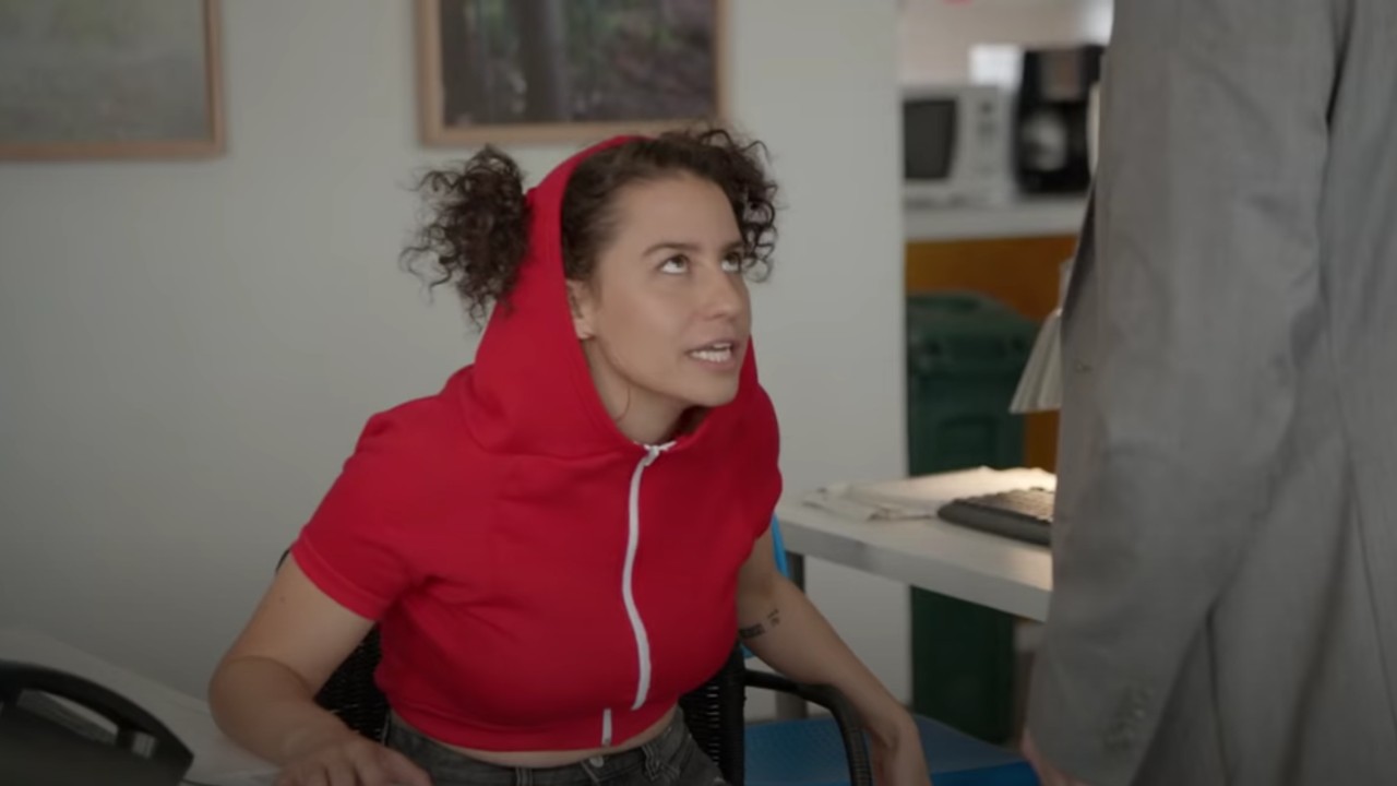 Ilana wearing her dog hoodie at work on Broad City