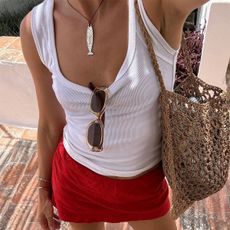 Woman in white tank top and red skirt