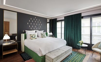 Hotel bedroom with large windows, green curtains and green decoration 