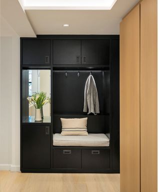 Entryway with black storage surrounded by wood