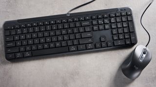 The Logitech K620 keyboard in a graphite grey colorway photographed as part of the MK625 como on able and white background.