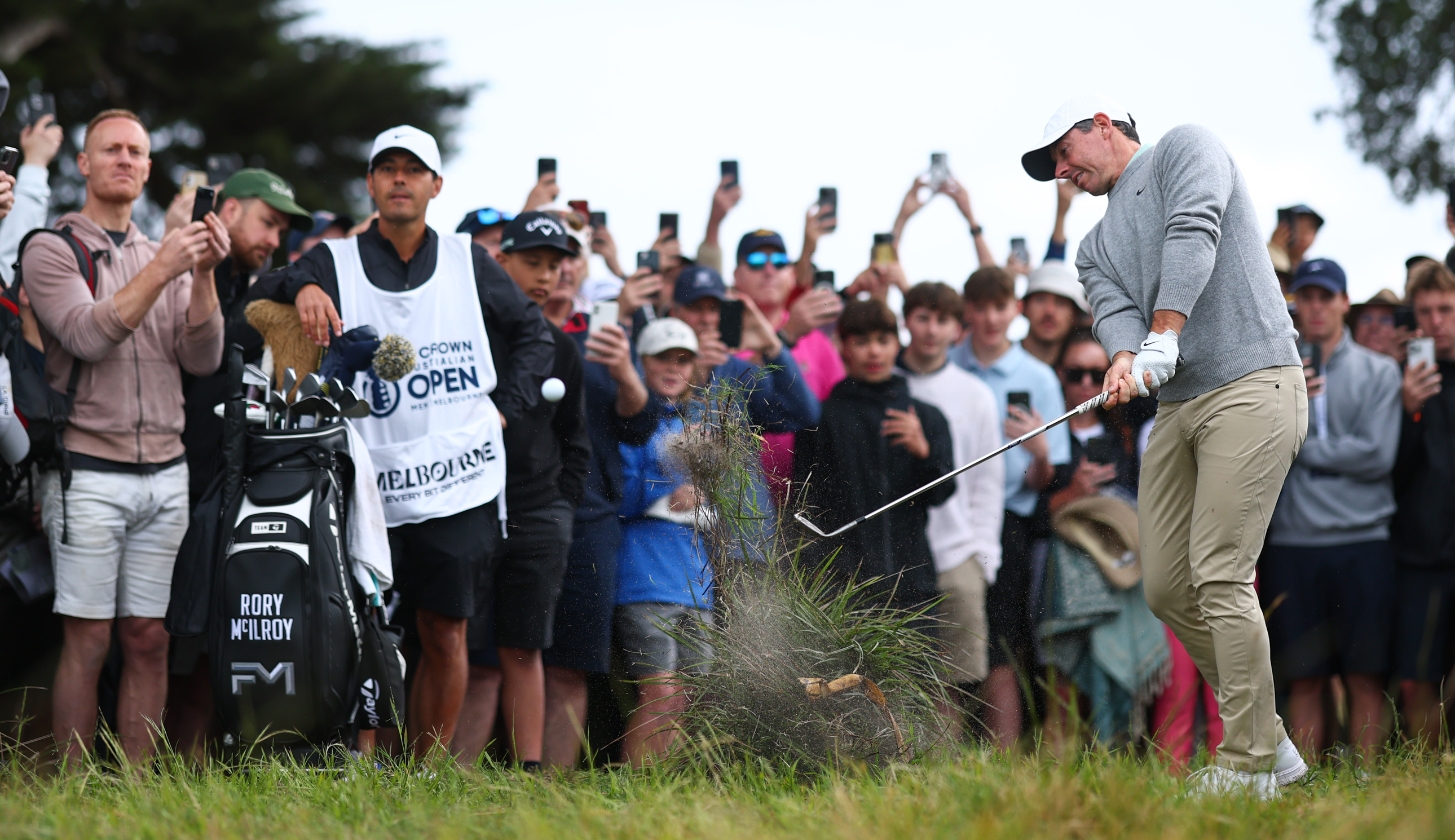 Rory McIlroy hits a golf ball out of a bush