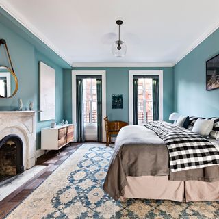 bedroom with blue walls and bold gingham bedding with nomadic-style prints