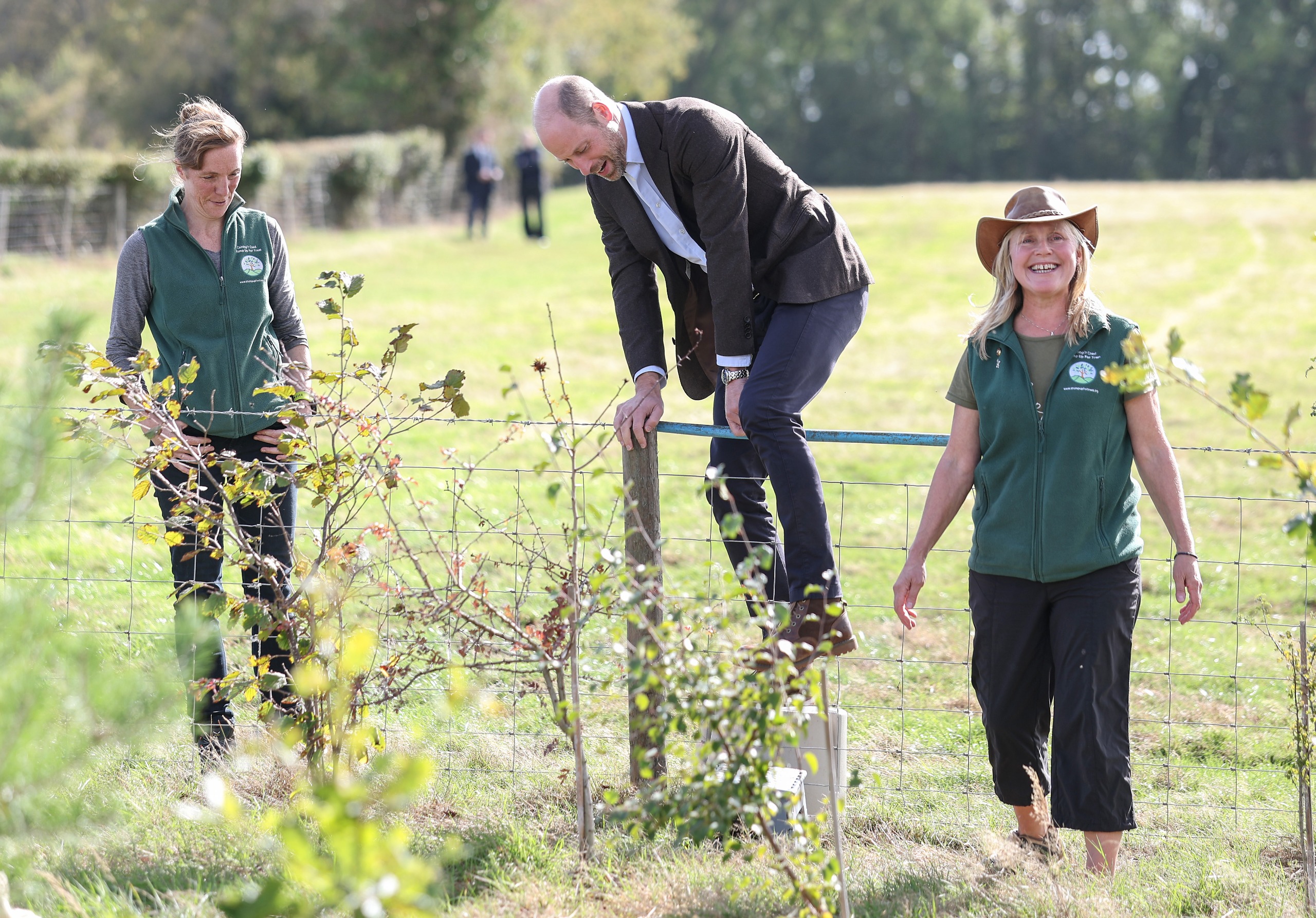 Prince William climbs over a wire fence during a visit to the charity Stump Up For Trees