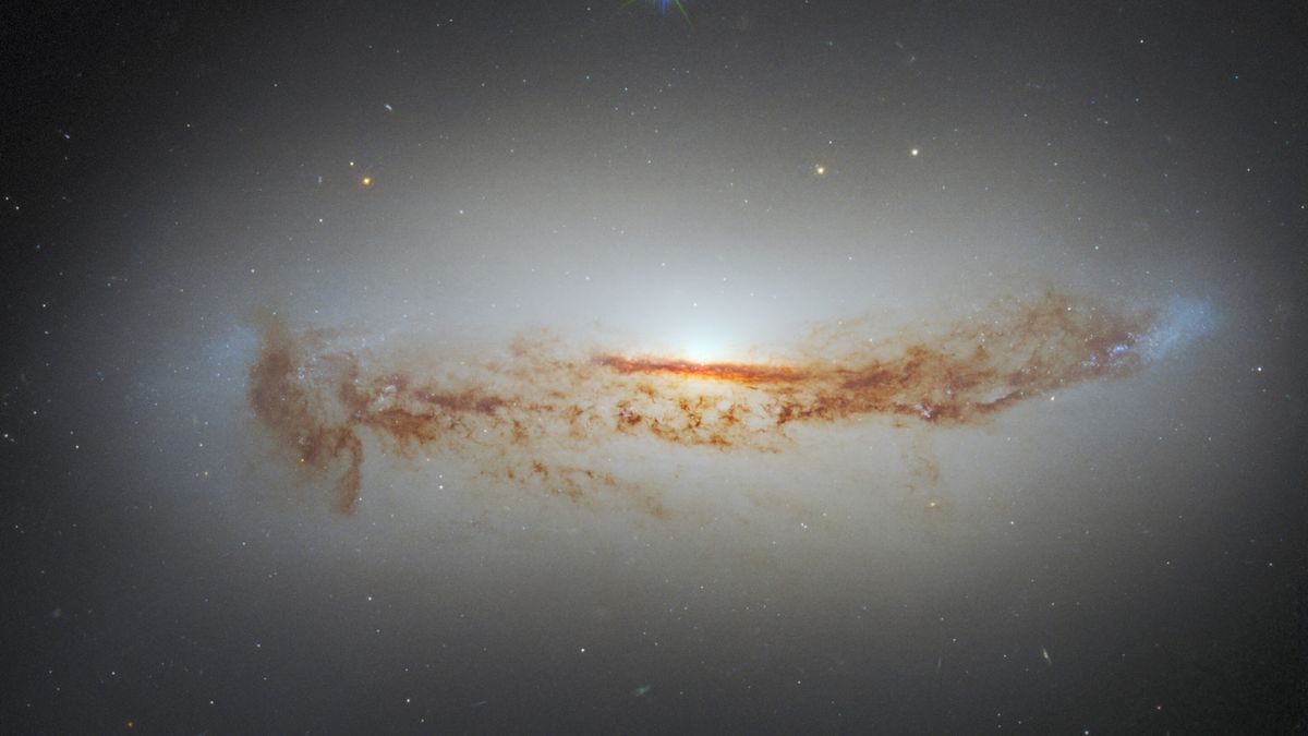 Ново изображение на Хъбъл показва ярката свръхмасивна черна дупка на галактиката, покрита с прах