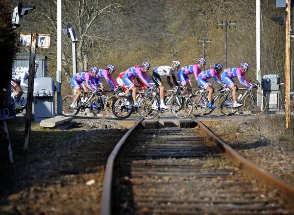 The peloton heads over a level crossing