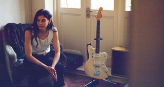 Bethia Beadman sits on a chair beside her Fender Jazzmaster