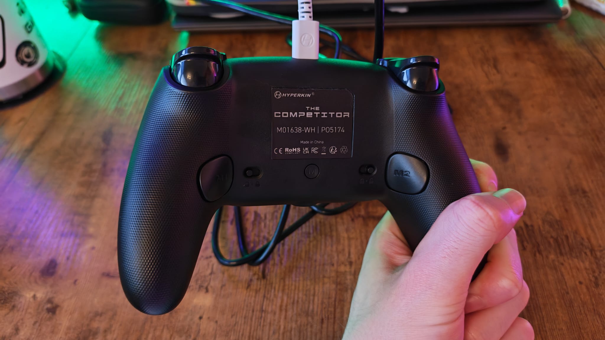 A reviewer showcasing the back of the Hyperkin Competitor