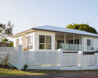 white concrete and timber paling fence outside house