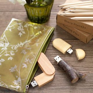 wooden surface with pendrive and pencil on it