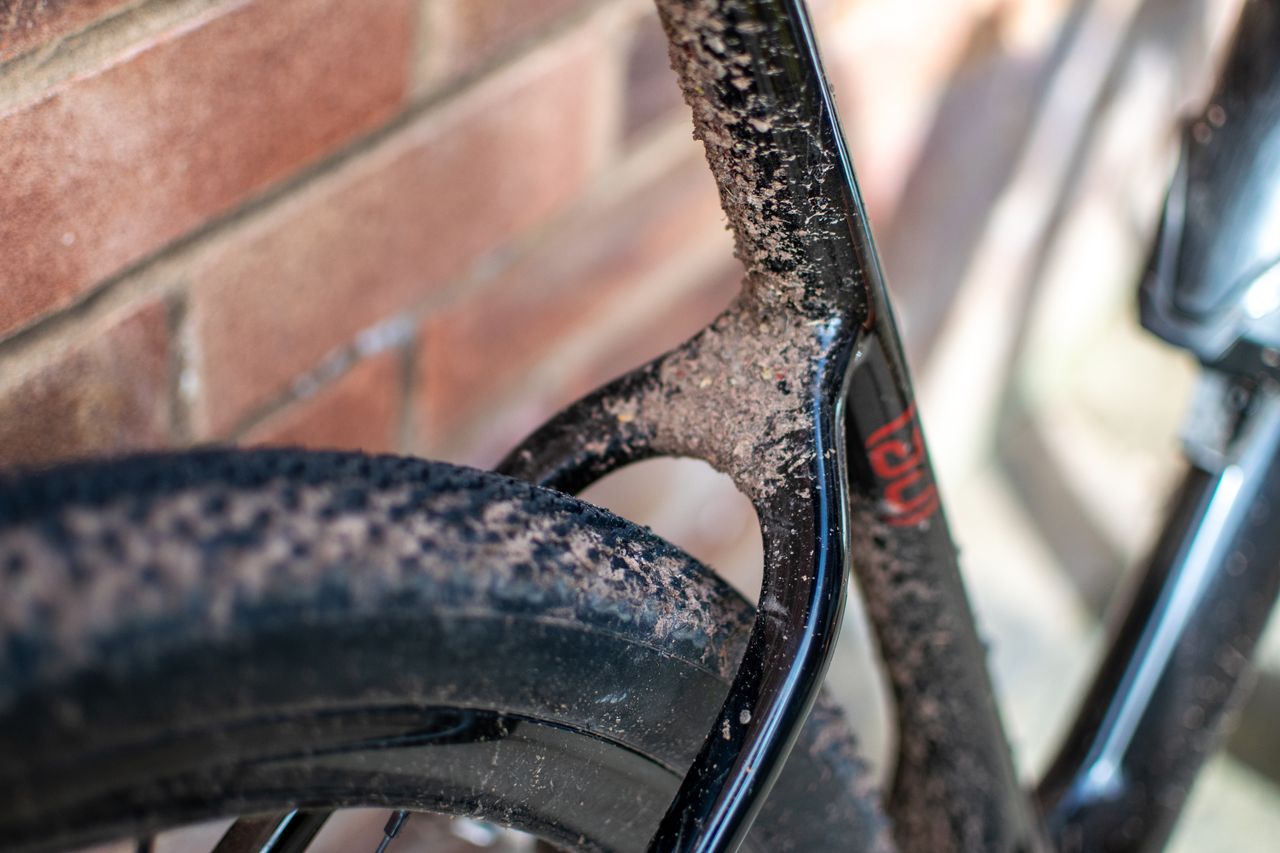A down tube of a gravel bike covered in mud