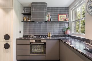 Small kitchen with black tiled splashback