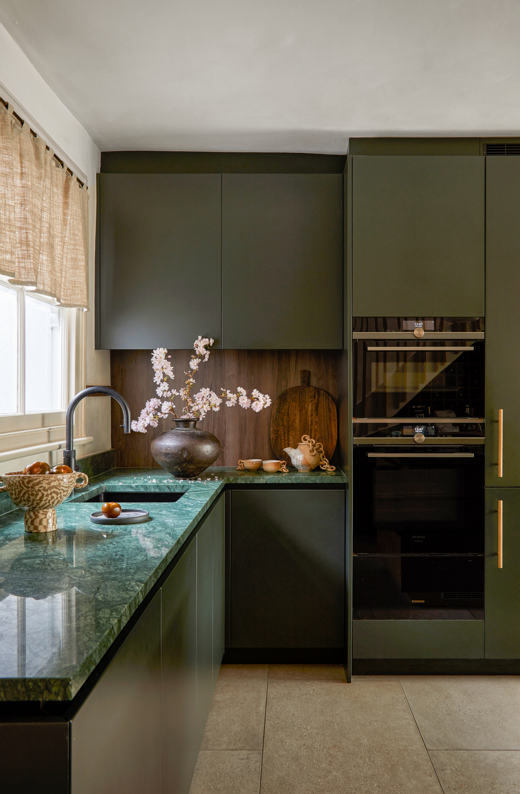 Dark green sleek kitchen cabinets with green stone worktops