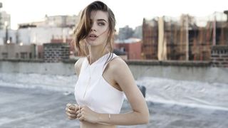 Girl in white on rooftop wearing AUrate jewelry