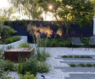 Pearly quartz pebbles and basalt plank pavers used in a garden landscape