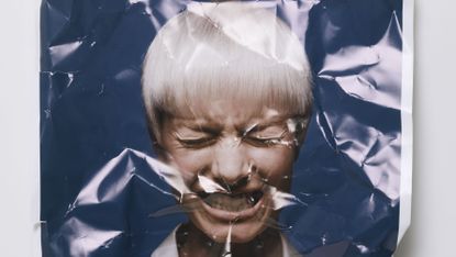 Crumpled photo of woman grimacing