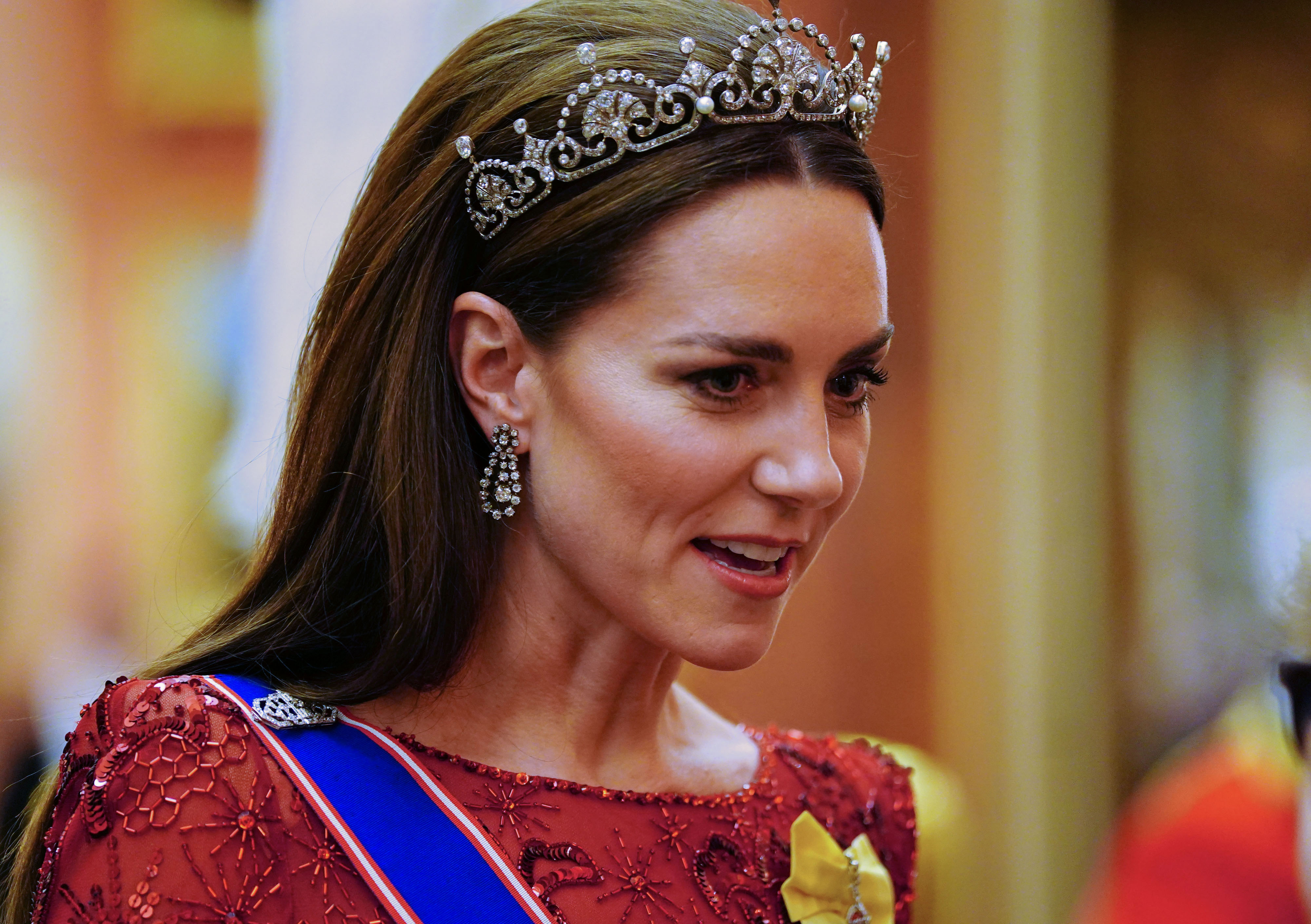 Princess Kate wearing a red gown and tiara