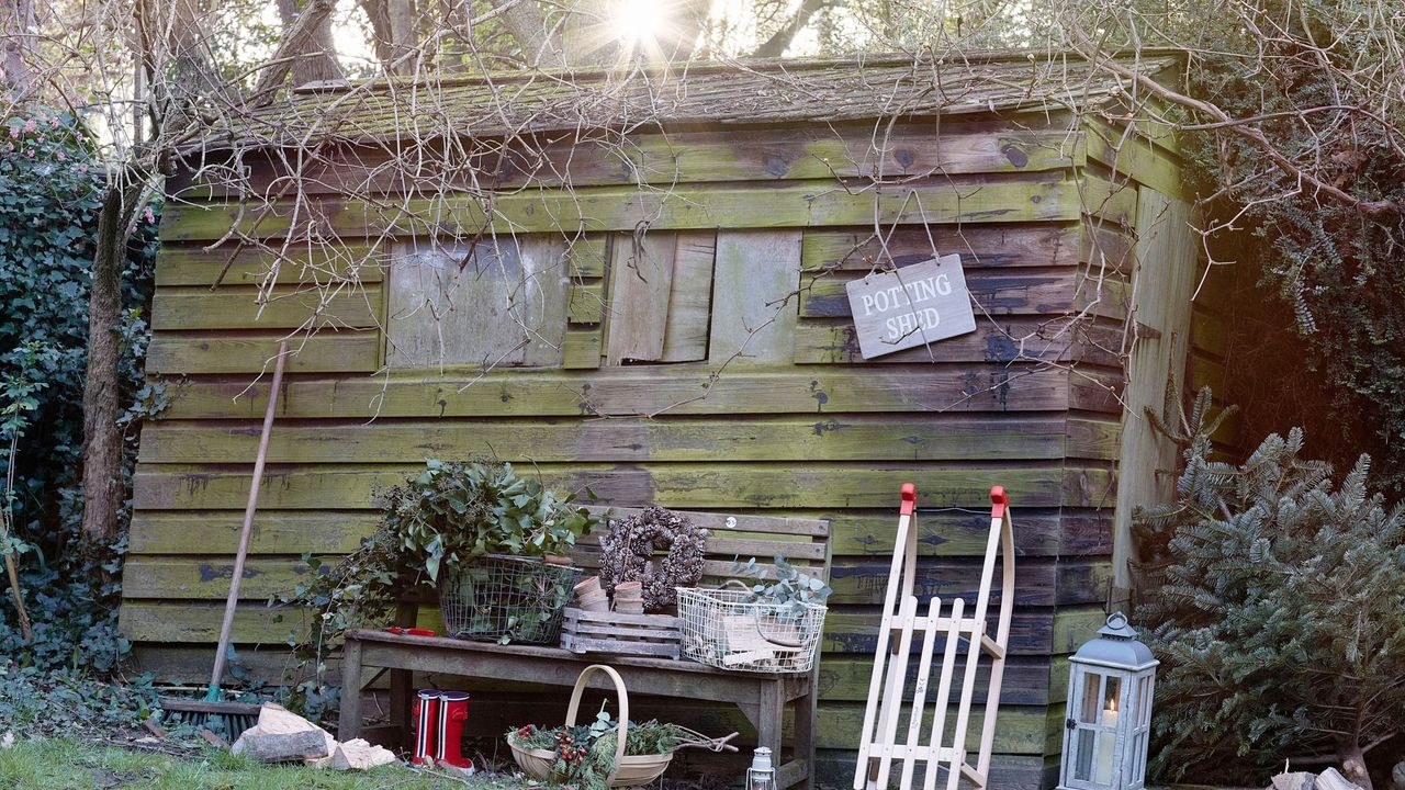 Wooden shed with potting shed sign in winter garden