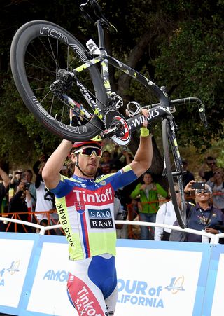 Peter Sagan lifts his bike over his head to celebrate overall victory