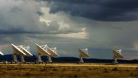 a set of large white antenna dishes in the desert