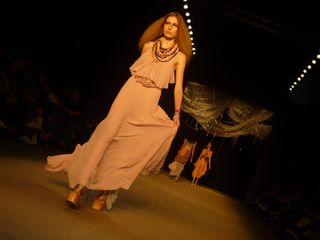 Model on a runway wearing a floaty, pink dress