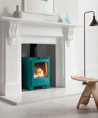 turquoise bioethanol stove installed in white fireplace