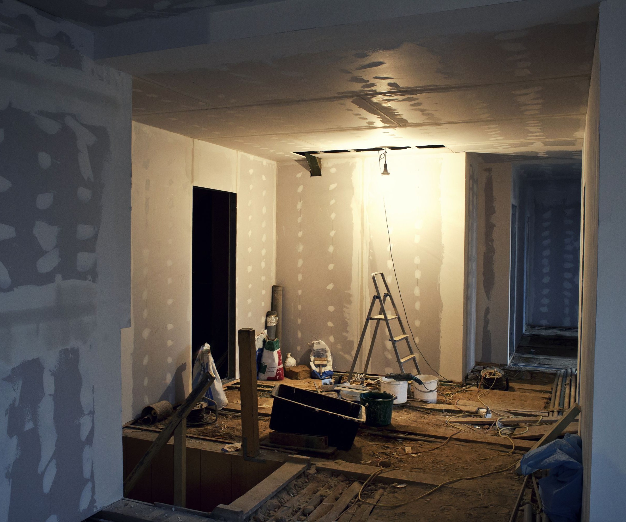 Inside a large room with plasterboard on the walls and a ladder in the background