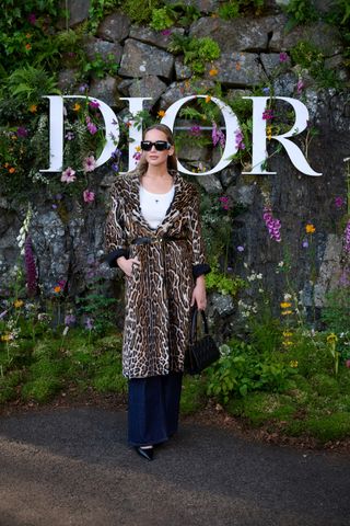 Jennifer Lawrence wearing a leopard print coat while attending the Dior Cruise show