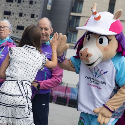 Princess Charlotte high fiving a unicorn mascot