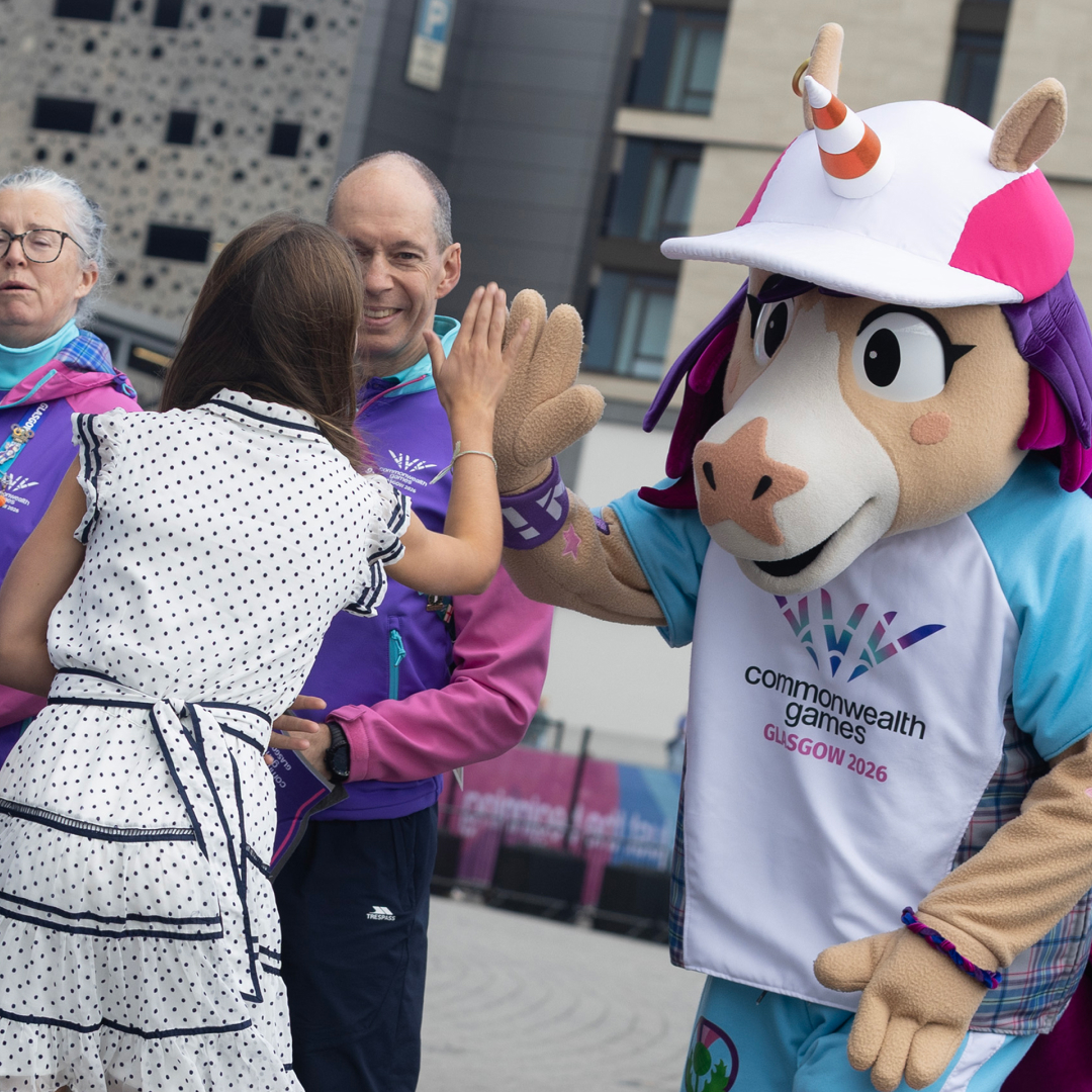 Princess Charlotte high fiving a unicorn mascot