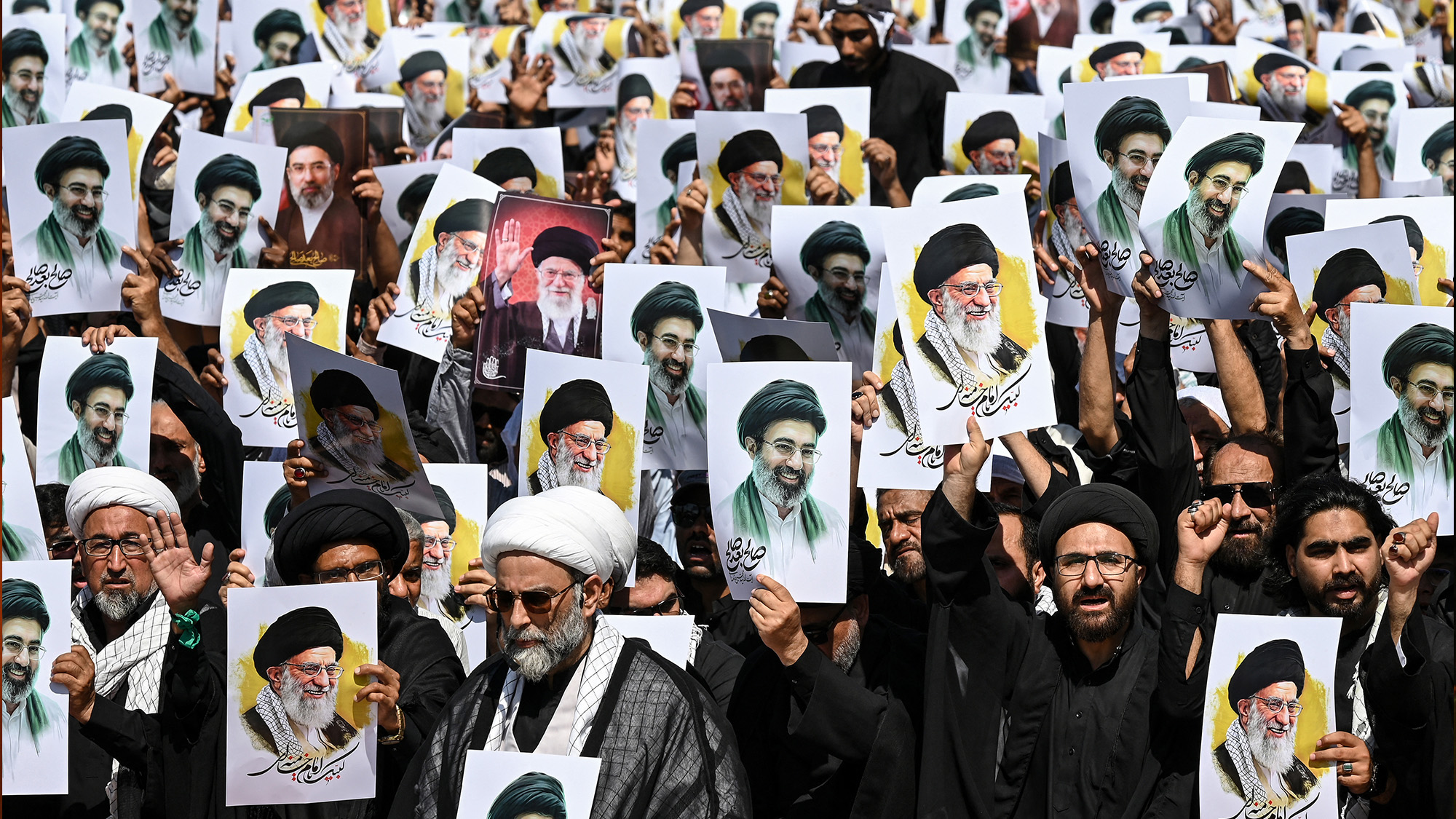 Shia Muslim men hold portraits of Ali Khamenei and of his son, Mojtaba Khamenei, and shout anti-US-Israel slogans at a procession in Karachi, Pakistan