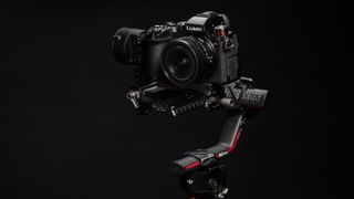 Panasonic Lumix S5D mirrorless camera attached to a DJI RS3 gimbal on a black background