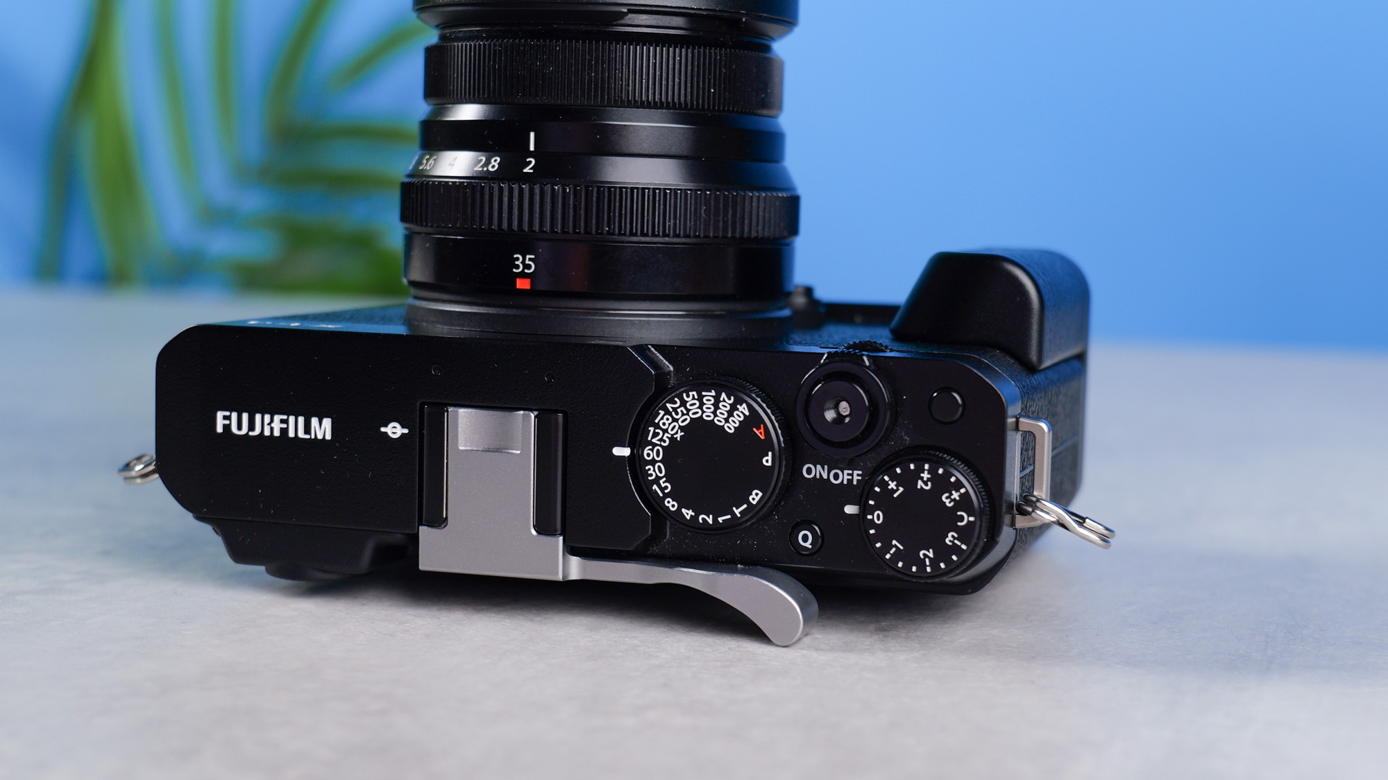 Fujifilm X-E4 on a stone surface and blue background