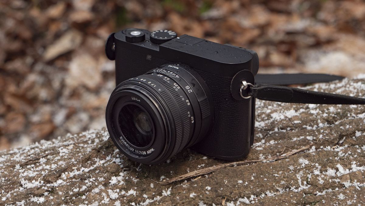Leica Q3 Monochrom compact camera outside on a snow-dusted log