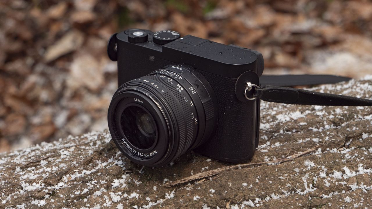 Leica Q3 Monochrom compact camera outside on a snow-dusted log