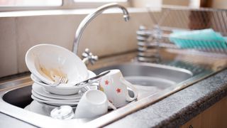 picture of dirty dishes piled in the kitchen sink