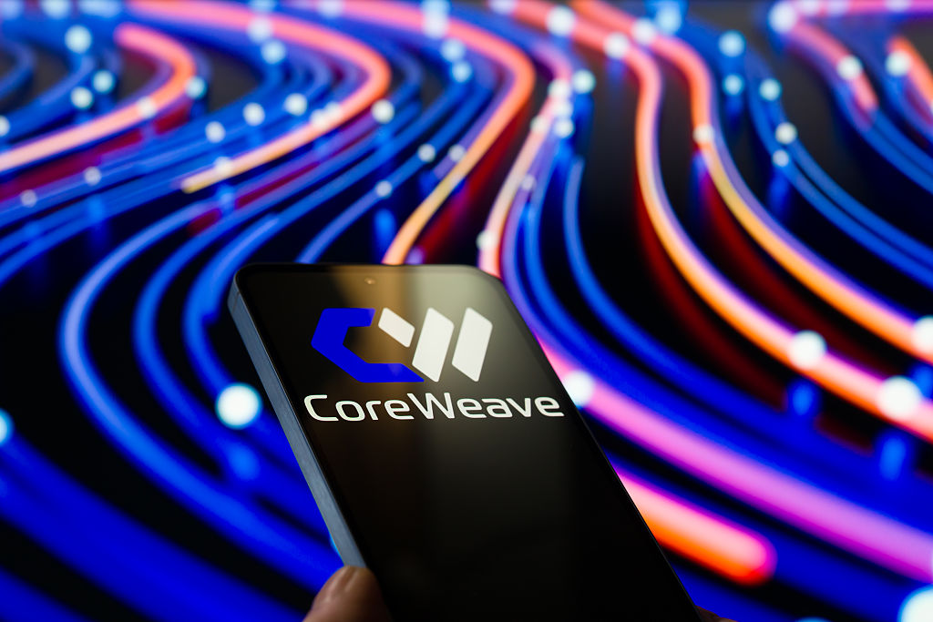 CoreWeave logo is displayed on a mobile phone